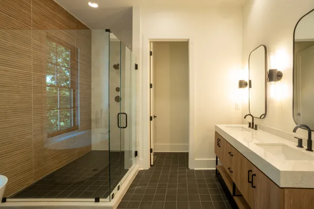 a bathroom with a double vanity sink a mirror and a shower