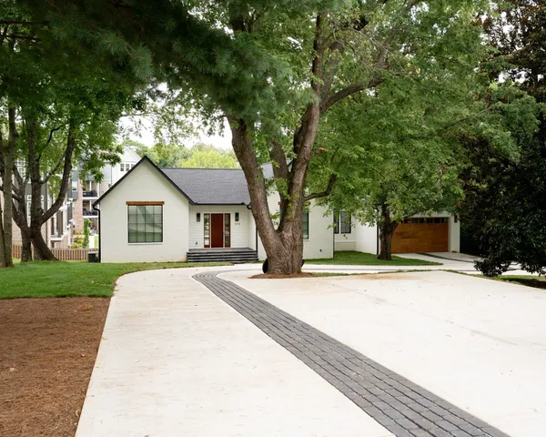 a front view of a house with yard and trees