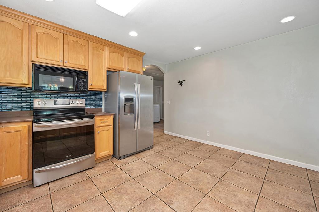 6181 Lambert Lane El Dorado, CA 95623 - Photo 30 of 68 kitchen with arched walkways, stainless steel appliances, tasteful backsplash, recessed lighting, and light wood finish cabinetry