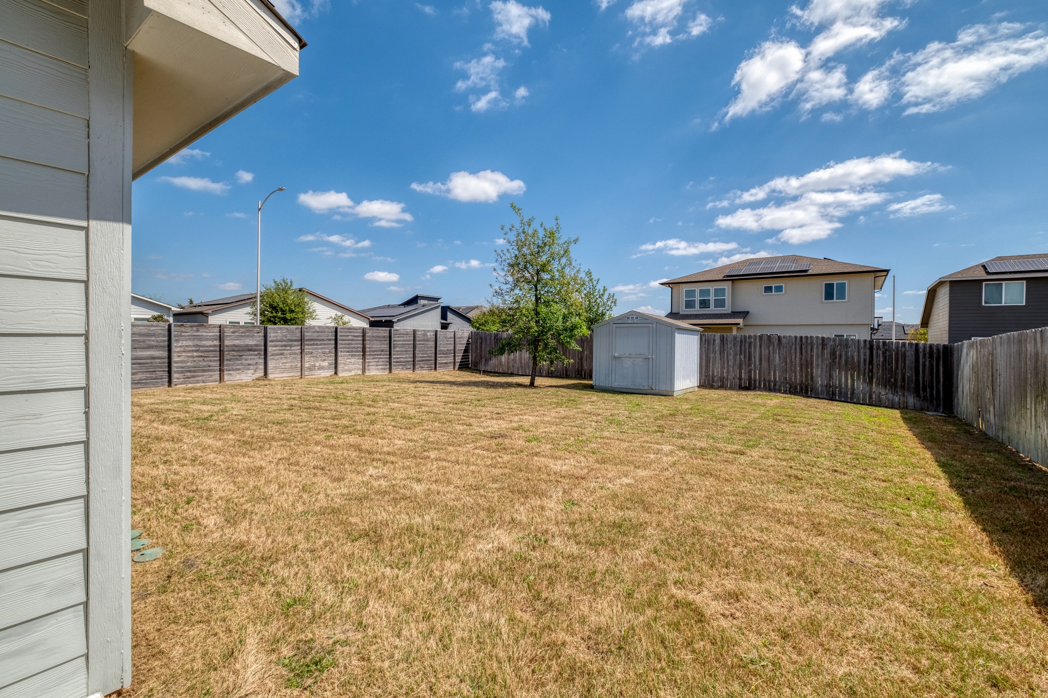 16400 Fetching Avenue Manor, TX 78653 - Photo 19 of 32 Fenced backyard with a storage shed and a residential view