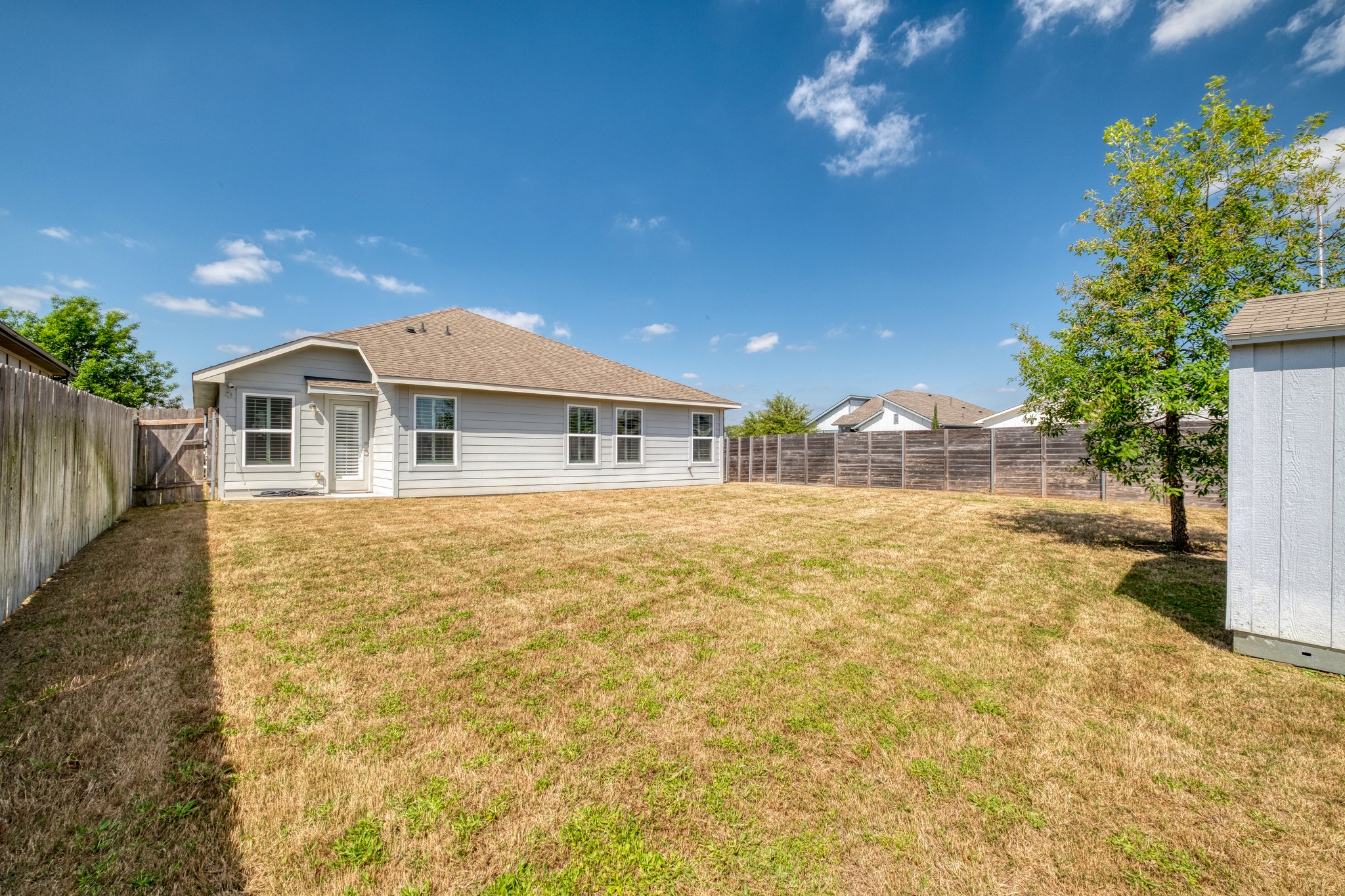 16400 Fetching Avenue Manor, TX 78653 - Photo 20 of 32 Back of property featuring a fenced backyard, a shingled roof, and a gate