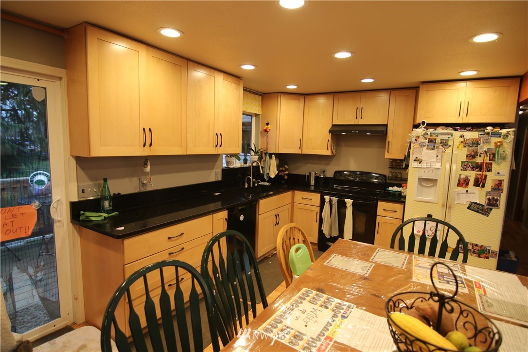 1518 South 28th Street Renton, WA 98055 - Photo 3 of 21 a kitchen with stainless steel appliances kitchen island granite countertop a stove a sink a refrigerator and blue cabinets with wooden floor