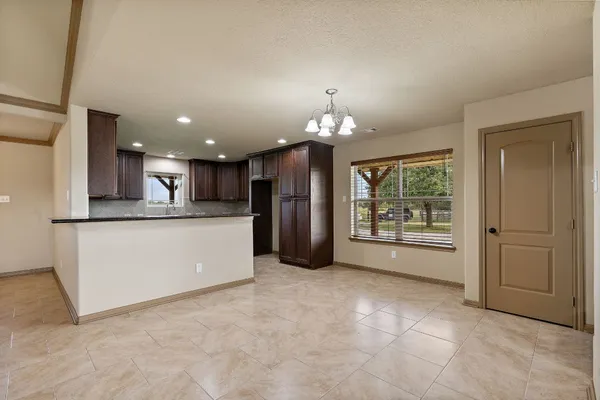 a kitchen with kitchen island granite countertop wooden cabinets a refrigerator and a sink