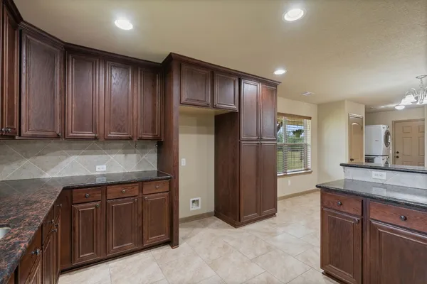 a kitchen with stainless steel appliances granite countertop wooden cabinets a stove a sink and a microwave