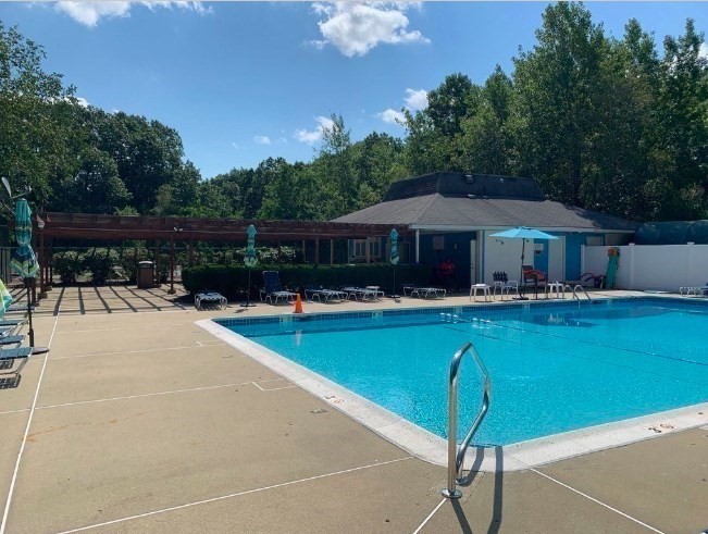 10 Beal's Cove Road, Unit E Hingham, MA 02043 - Photo 8 of 10 a swimming pool with outdoor seating and yard
