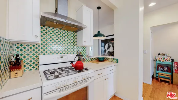 a kitchen with a stove and a white cabinets