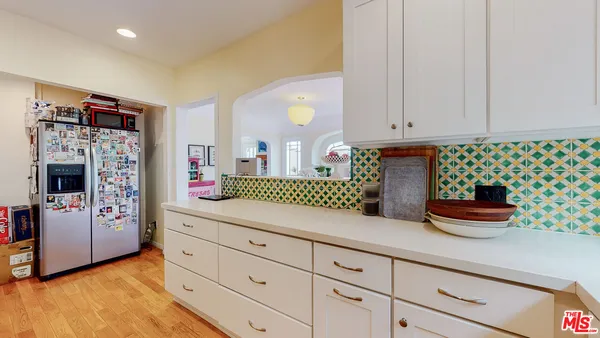 a kitchen with granite countertop white cabinets and stainless steel appliances