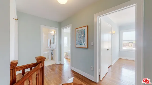 a view of a hallway with wooden floor and staircase