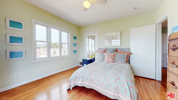 a bedroom with a bed and wooden floor