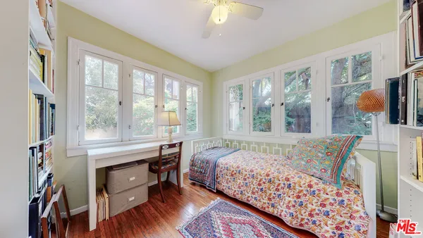 a bedroom with a bed and a large window with outer view