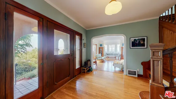 a view of a room with wooden floor and furniture