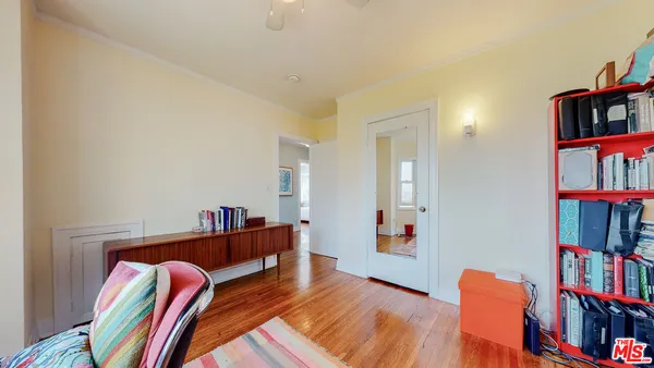 a living room with baby crib and dresser