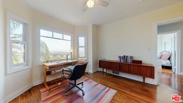 a work room with furniture wooden floor and a window