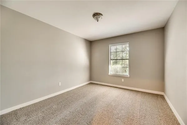 a view of a big room with windows and chandelier fan