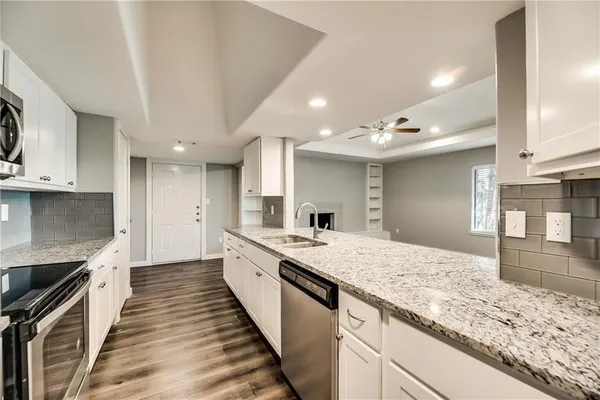 a large kitchen with kitchen island granite countertop a large counter top and wooden floor