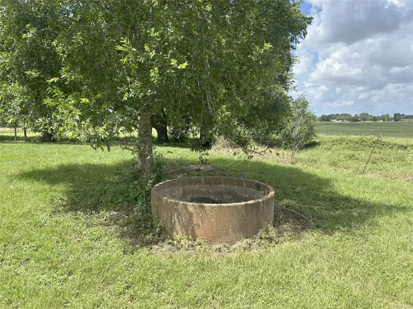 an aerial view of a residential houses with outdoor space and tennis court