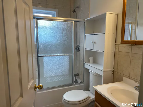an empty room with wooden floor cabinet and windows