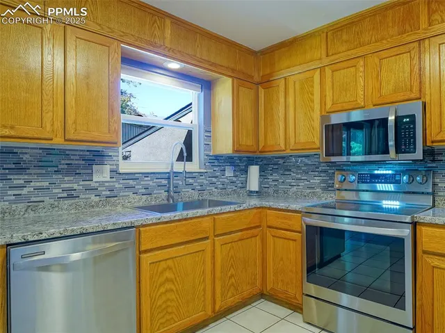 a kitchen with granite countertop cabinets stainless steel appliances and a sink
