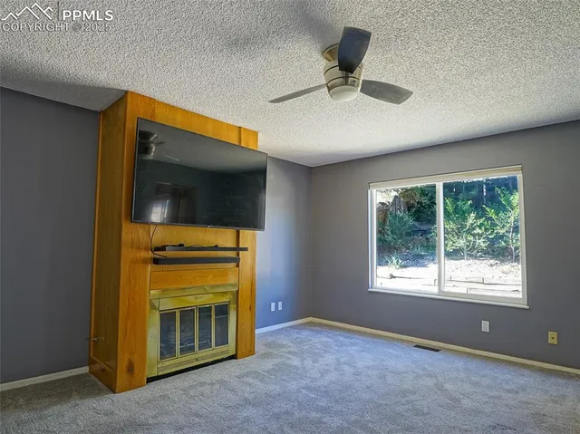 a living room with a fireplace and a ceiling fan