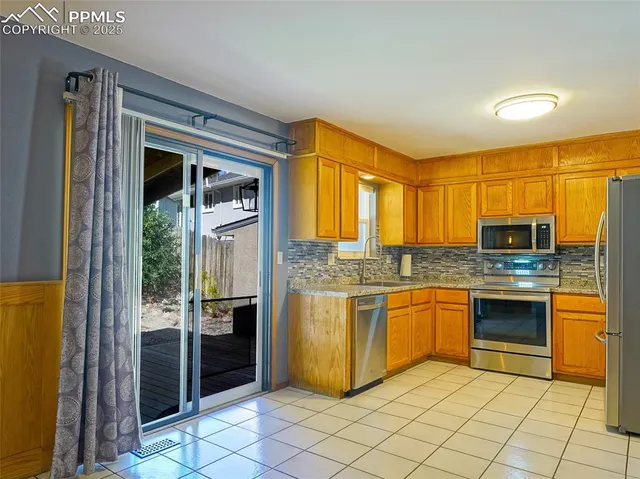a kitchen with stainless steel appliances granite countertop a refrigerator and a stove top oven