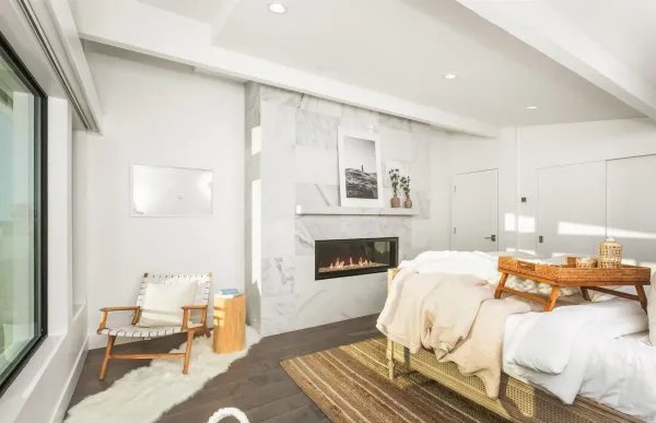 a bedroom with a bed lamp and a large window