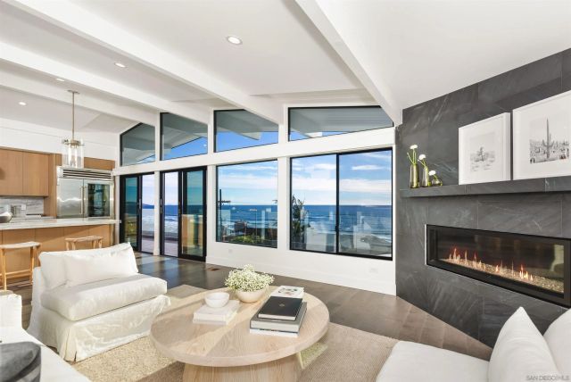 a living room with furniture a fireplace and a floor to ceiling window