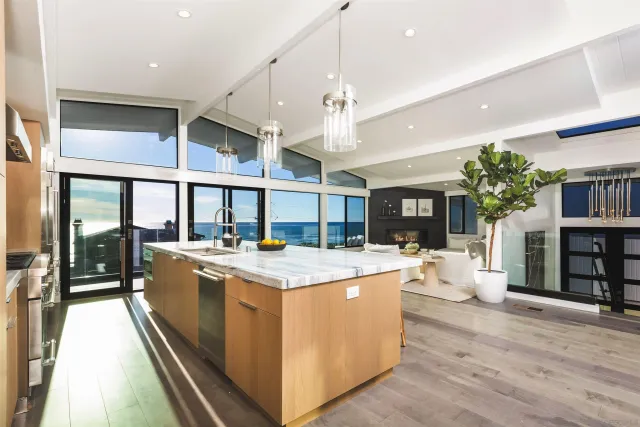 a view of a kitchen with kitchen island a large counter space appliances and a dining table