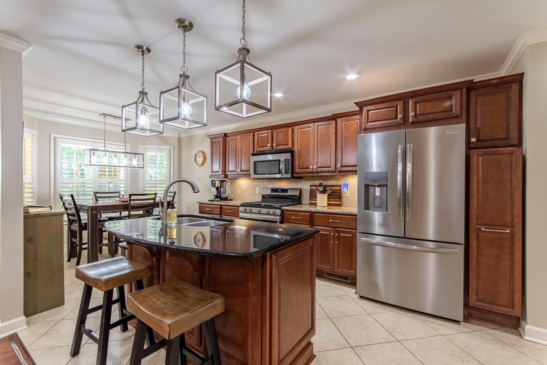 115 Partridge Lane Savannah, TN 38372 - Photo 13 of 40 a kitchen with stainless steel appliances granite countertop a refrigerator a sink dishwasher a dining table and chairs with wooden floor