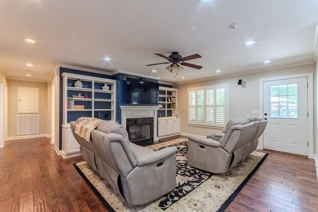 a living room with furniture fireplace and wooden floor