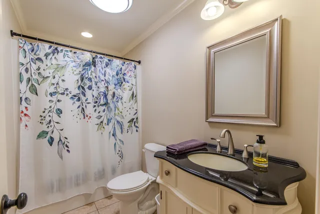 a bathroom with a granite countertop sink mirror vanity and toilet