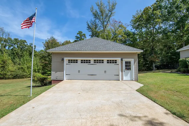a view of a house with a yard and potted plants