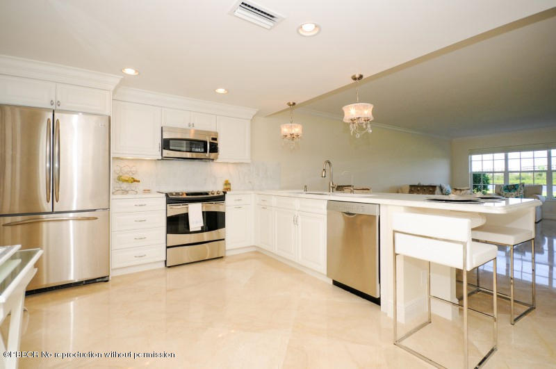 2185 Ibis Isle Road, Unit 2 Palm Beach, FL 33480 - Photo 6 of 26 a kitchen with white cabinets and stainless steel appliances