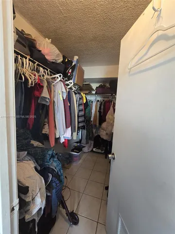 a view of walk in closet with clothes