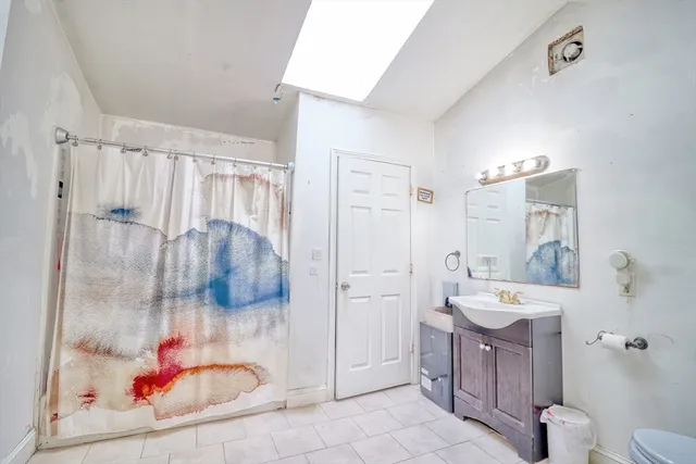 a bathroom with a tub sink mirror and toilet
