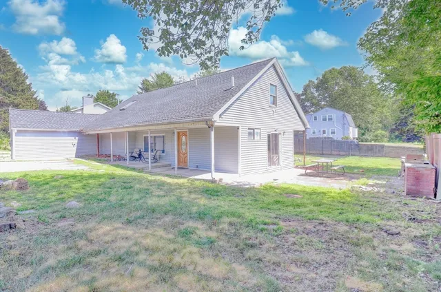 a view of a house with a yard and sitting area