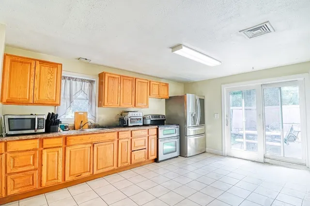 a kitchen with stainless steel appliances a refrigerator sink and cabinets