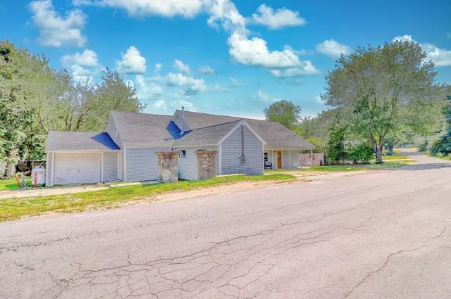 a view of the house with a big yard and large trees