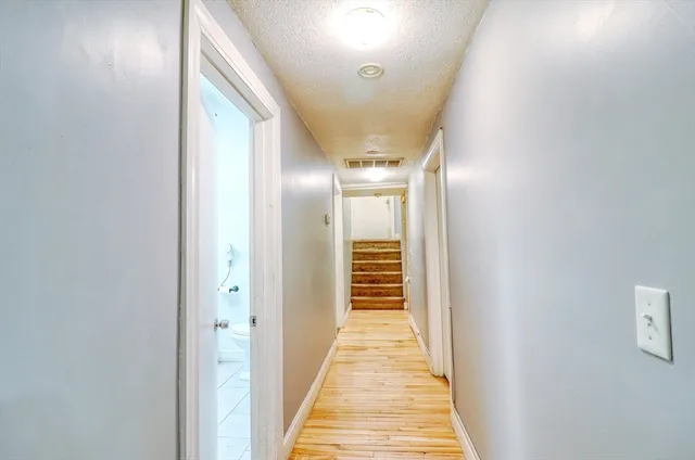 a view of a hallway with wooden floor