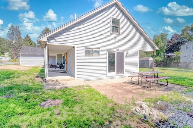 a view of a house with backyard and a tree