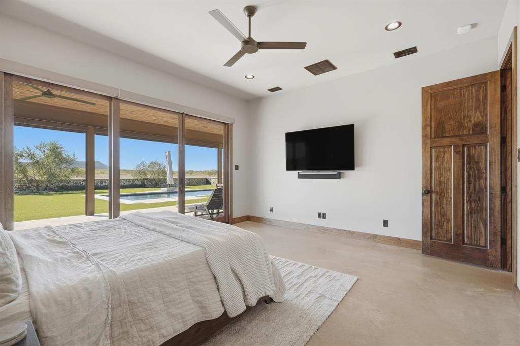 483 County Road 353 Merkel, TX 79536 - Photo 20 of 40 a bed room with a large window and a flat screen tv