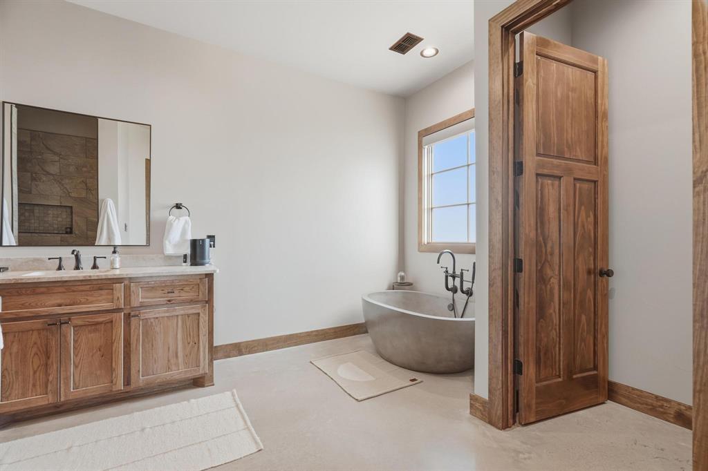 483 County Road 353 Merkel, TX 79536 - Photo 22 of 40 a spacious bathroom with a double vanity sink a mirror and a bathtub