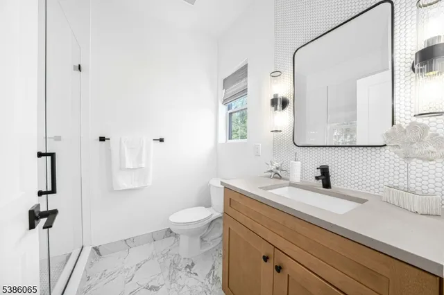 a bathroom with a sink a toilet and a mirror