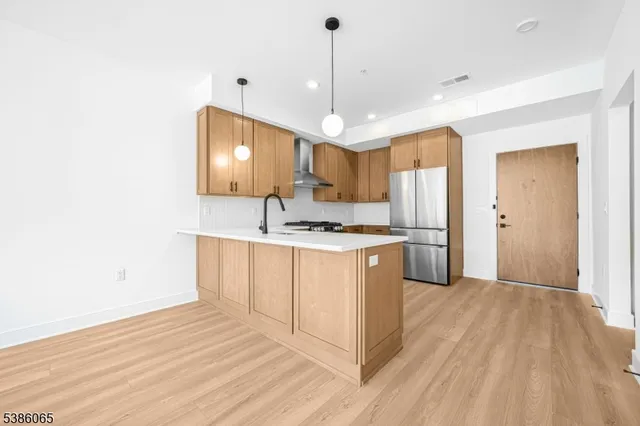 a kitchen with a refrigerator a sink and cabinets