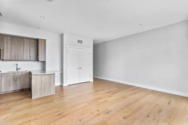 a view of a kitchen with wooden floor and cabinets