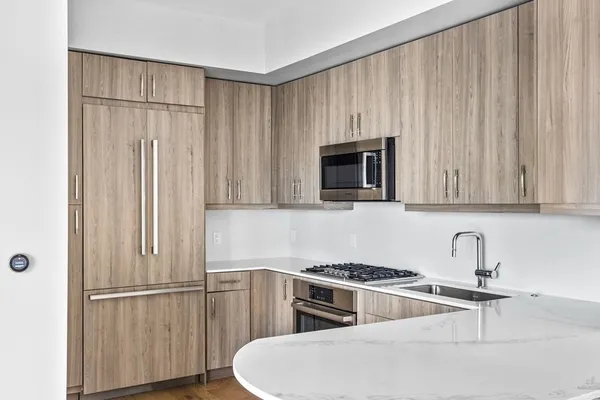 a kitchen with appliances a sink and cabinets