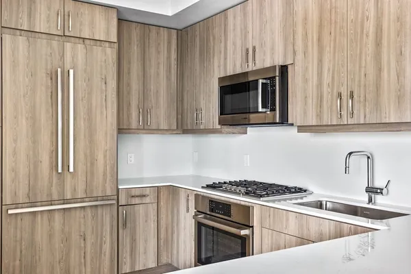 a kitchen with stainless steel appliances white cabinets and a stove top oven