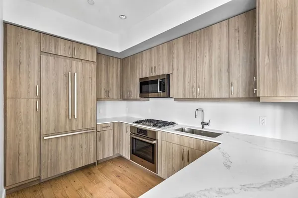 a kitchen with stainless steel appliances granite countertop a refrigerator a sink and a stove top oven