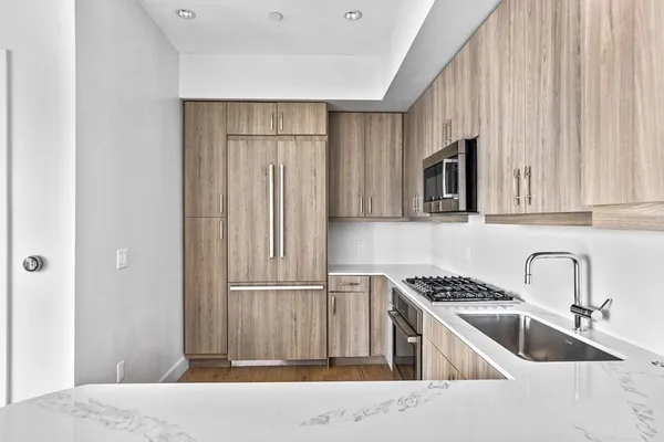 a kitchen with stainless steel appliances granite countertop a sink and a refrigerator