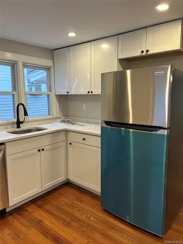 a kitchen with a refrigerator sink and cabinets