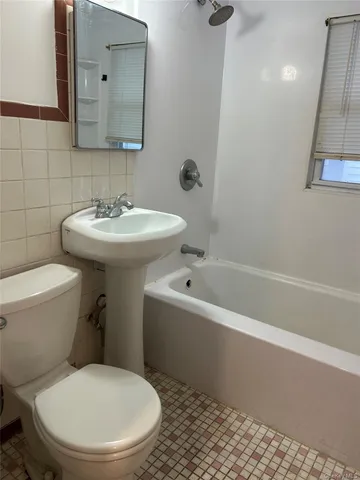 a white toilet sitting next to a bath tub
